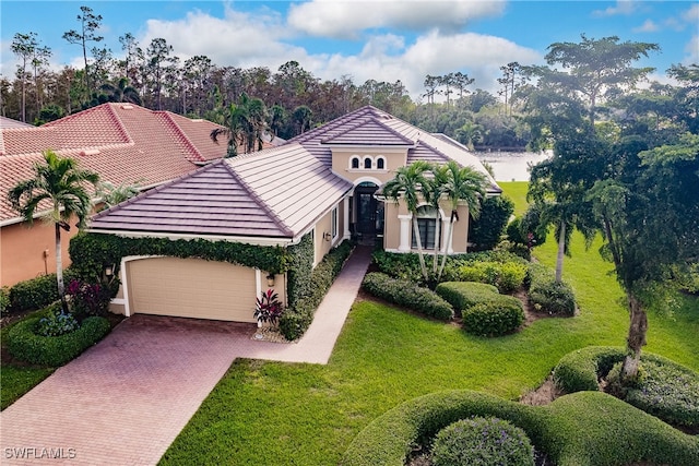 mediterranean / spanish-style home with a garage and a front yard