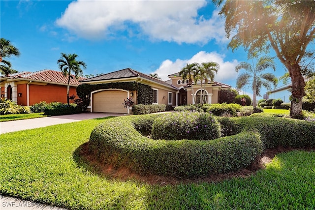 mediterranean / spanish home featuring a garage and a front lawn