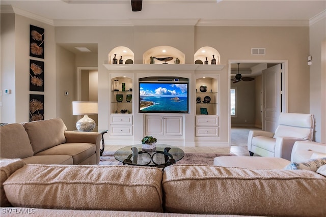 living room with built in shelves, light tile patterned floors, ceiling fan, and crown molding