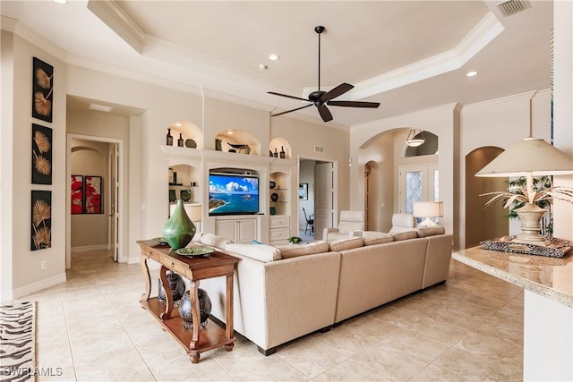 living room with ornamental molding, light tile patterned flooring, ceiling fan, and a tray ceiling