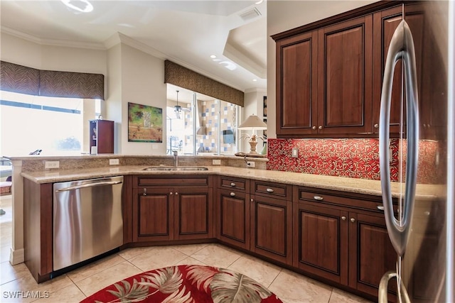 kitchen featuring sink, ornamental molding, appliances with stainless steel finishes, kitchen peninsula, and backsplash