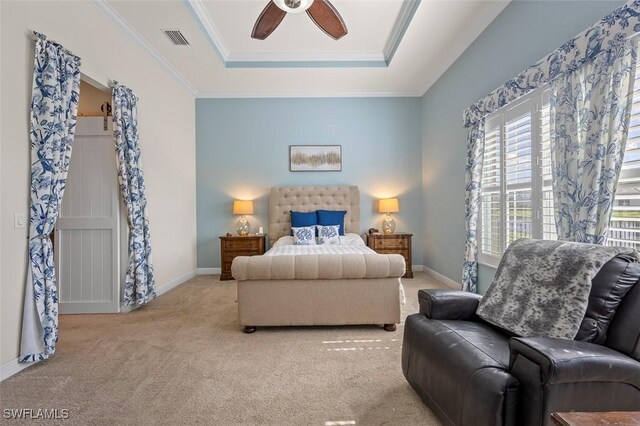 carpeted bedroom with a raised ceiling, ceiling fan, and crown molding