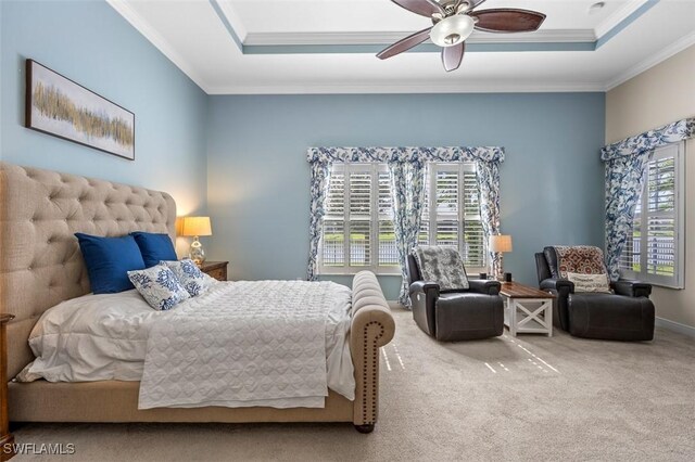 bedroom featuring ceiling fan, carpet floors, crown molding, and a tray ceiling