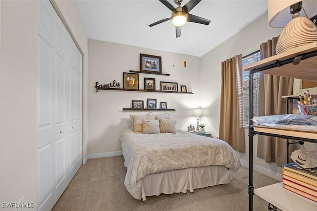 bedroom featuring a ceiling fan, baseboards, a closet, and light colored carpet