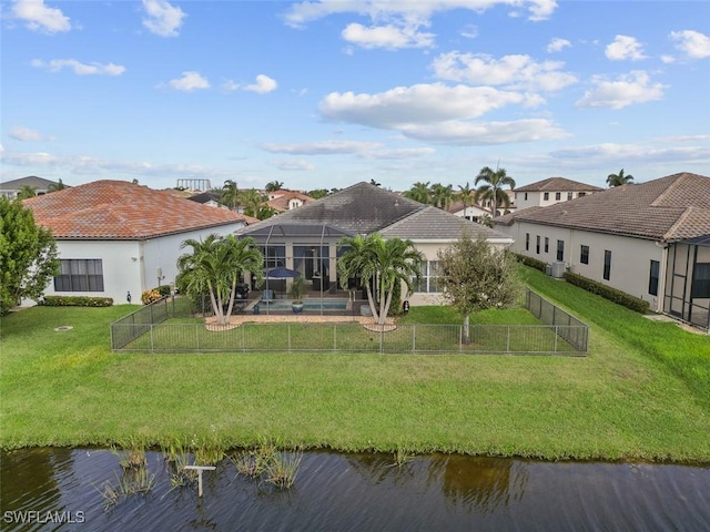 back of property featuring a lanai, a water view, and a lawn