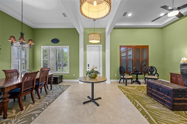 interior space featuring ceiling fan with notable chandelier and a tray ceiling