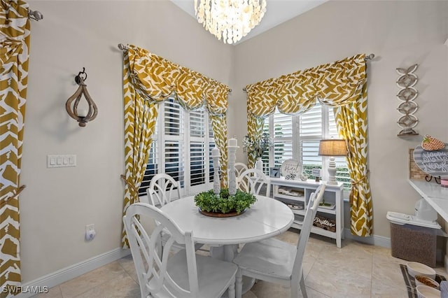 dining area with light tile patterned floors, baseboards, and a chandelier