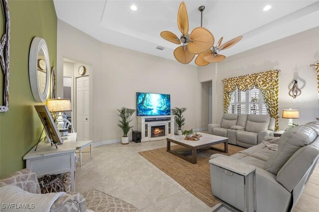 living room featuring ceiling fan and a tray ceiling