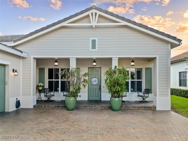 view of front facade featuring covered porch and stucco siding