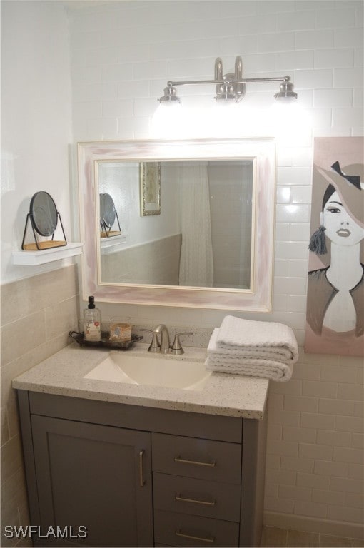 bathroom featuring vanity and tile walls