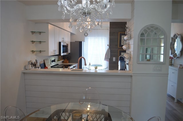 kitchen featuring hardwood / wood-style flooring, white cabinets, and stainless steel appliances