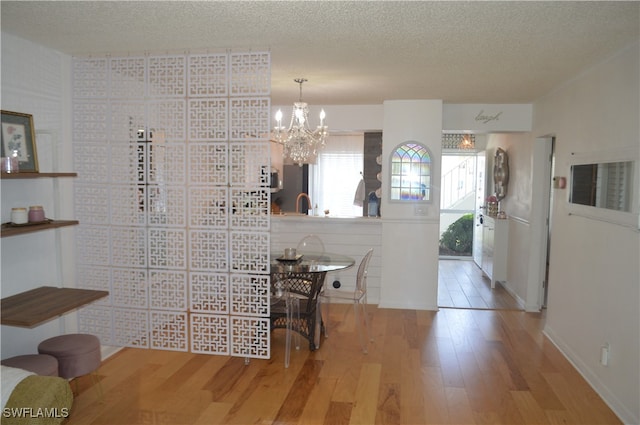 dining space featuring hardwood / wood-style floors, a chandelier, and a textured ceiling