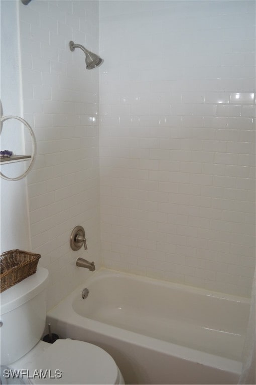 bathroom featuring toilet and tiled shower / bath