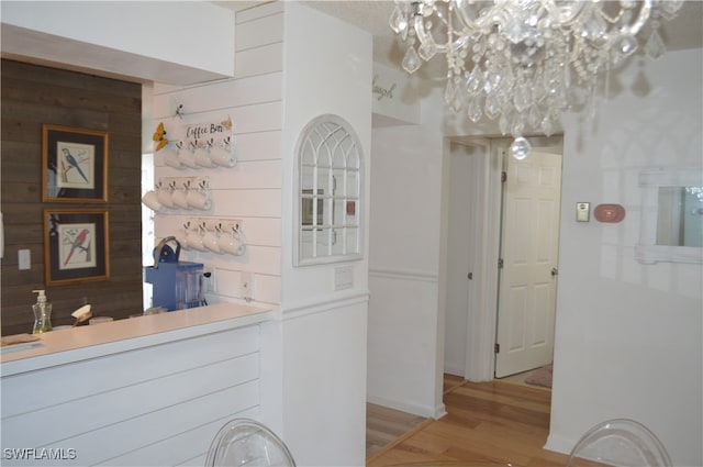 hall featuring hardwood / wood-style flooring and an inviting chandelier