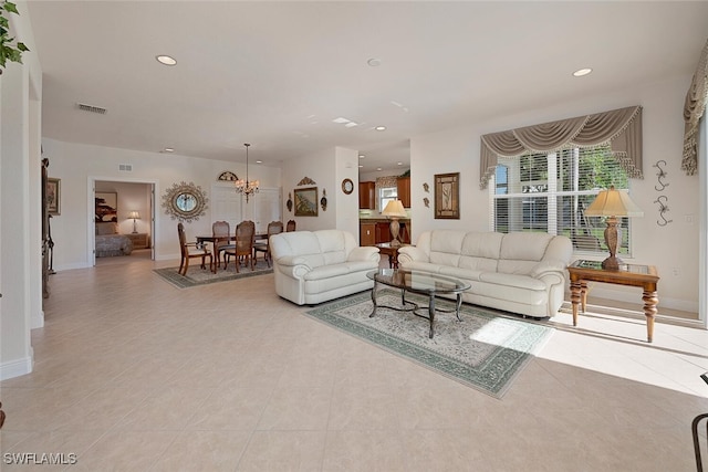 tiled living room featuring a notable chandelier