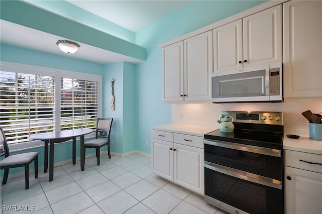 kitchen featuring backsplash, light tile patterned flooring, white cabinetry, and stainless steel appliances