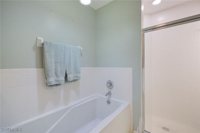 bathroom featuring shower with separate bathtub