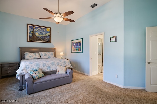 carpeted bedroom with ensuite bathroom and ceiling fan