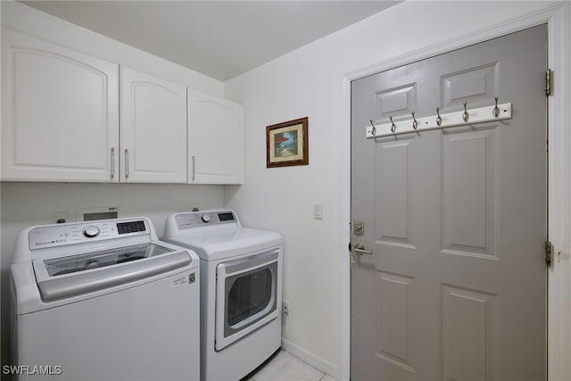 washroom with washer and dryer, cabinets, and light tile patterned floors