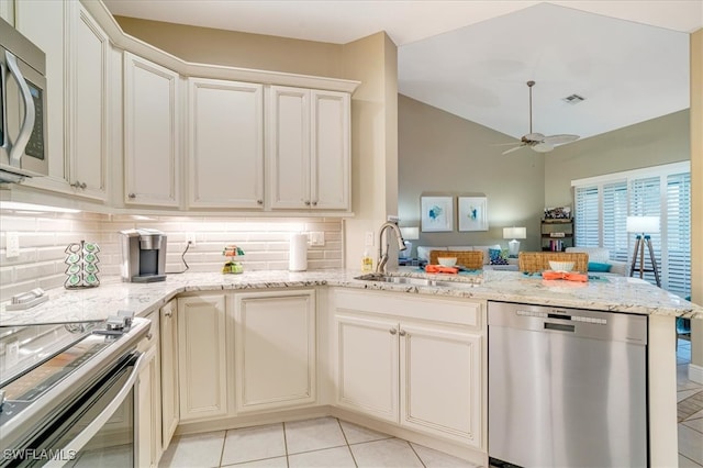 kitchen with appliances with stainless steel finishes, sink, vaulted ceiling, ceiling fan, and kitchen peninsula