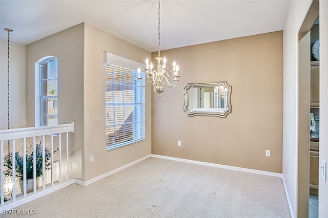 unfurnished room with carpet flooring and an inviting chandelier