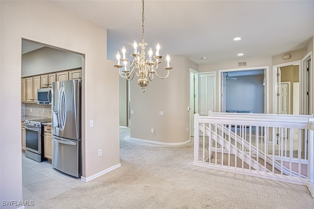 kitchen featuring light carpet, stainless steel appliances, tasteful backsplash, and a chandelier