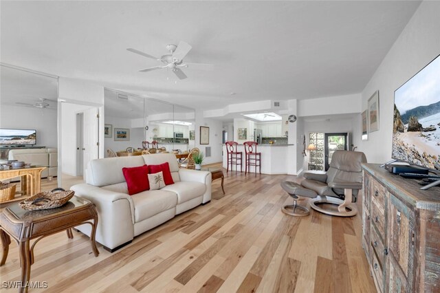 living room with ceiling fan and light hardwood / wood-style floors