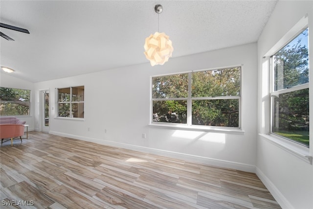 interior space with a textured ceiling, light hardwood / wood-style flooring, ceiling fan, and lofted ceiling