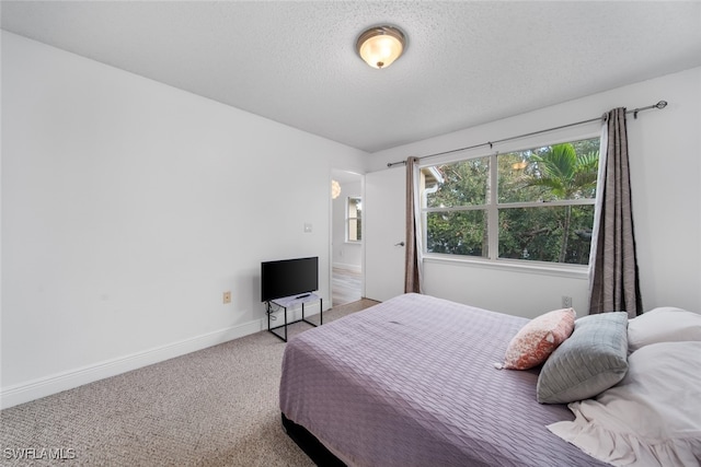 bedroom with carpet floors and a textured ceiling