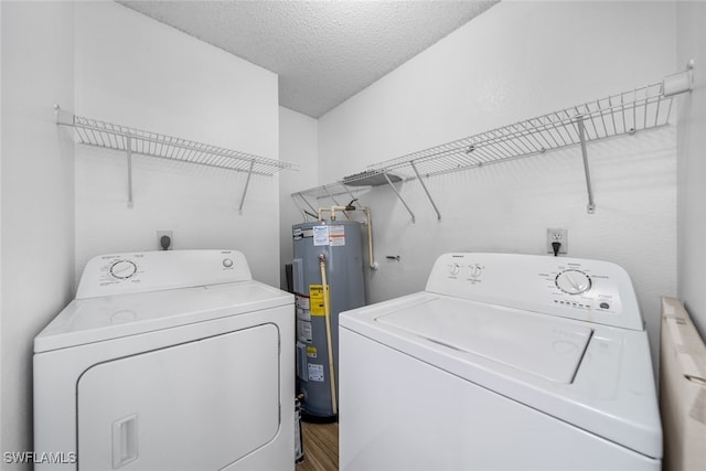 laundry room featuring a textured ceiling, separate washer and dryer, hardwood / wood-style flooring, and water heater