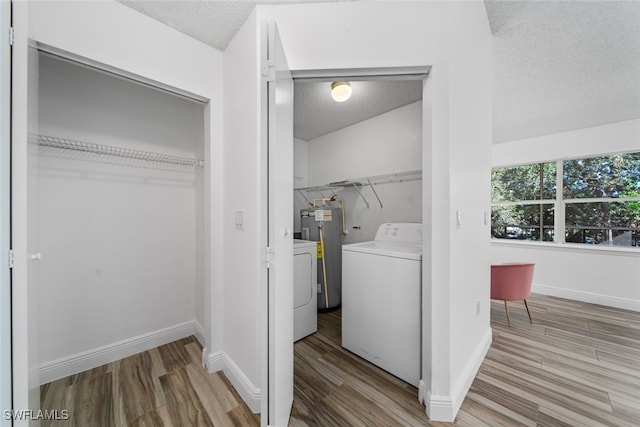 laundry room featuring hardwood / wood-style floors, washer and dryer, electric water heater, and a textured ceiling