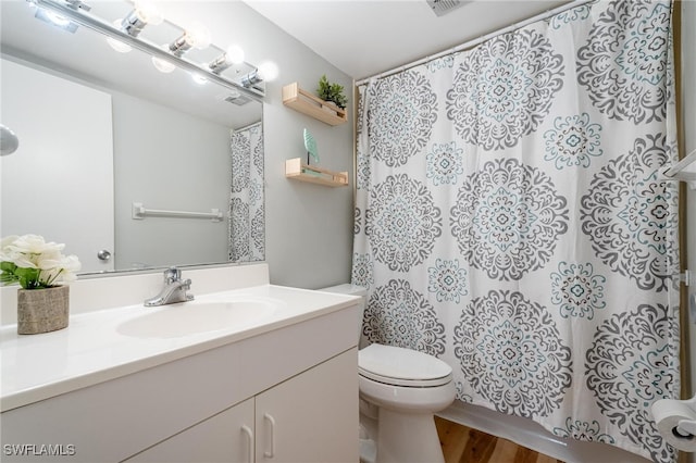 bathroom featuring wood-type flooring, vanity, and toilet