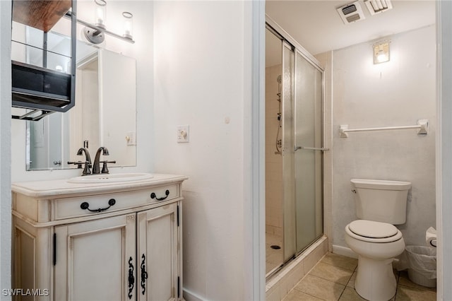 bathroom featuring tile patterned flooring, toilet, vanity, and walk in shower