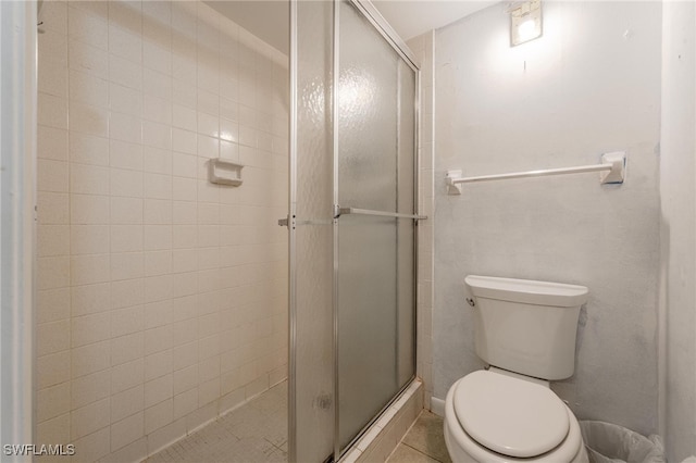 bathroom with tile patterned flooring, toilet, and walk in shower