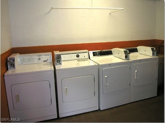 washroom with washer and dryer and dark tile patterned flooring