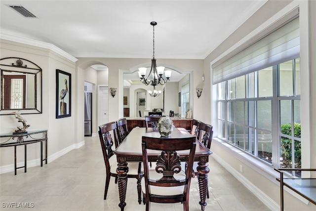 tiled dining space featuring a chandelier and crown molding