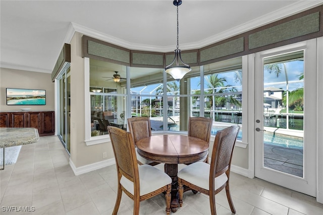 tiled dining area featuring ceiling fan, ornamental molding, and french doors