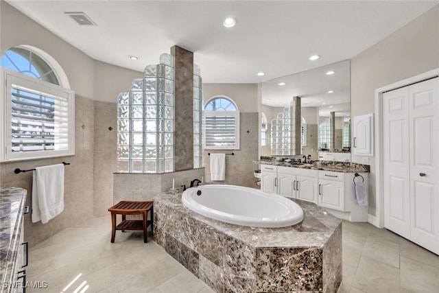 bathroom with separate shower and tub, a wealth of natural light, tile patterned floors, and vanity