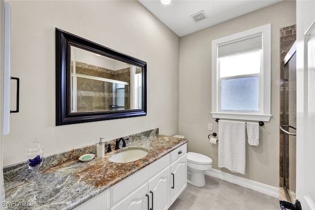 bathroom featuring vanity, toilet, and a shower with door