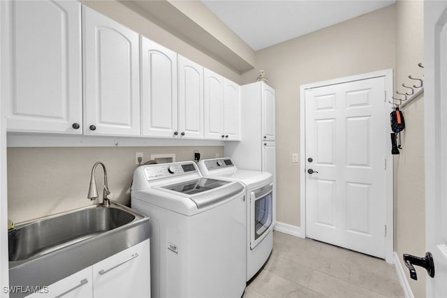 washroom with washer and dryer, light tile patterned flooring, cabinets, and sink