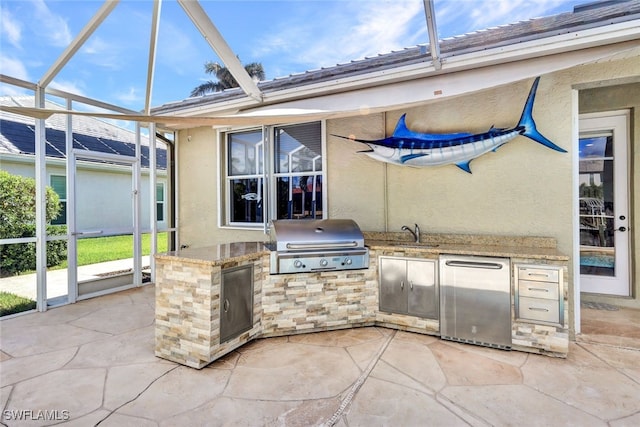 view of patio featuring a lanai, grilling area, sink, and exterior kitchen