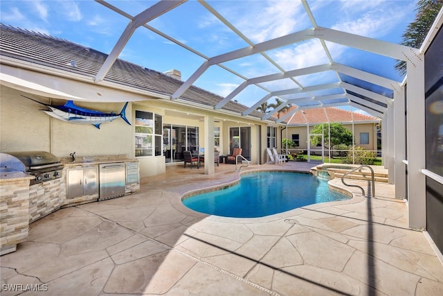 view of pool with a lanai, an outdoor kitchen, grilling area, and a patio area