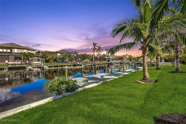 dock area with a yard and a water view