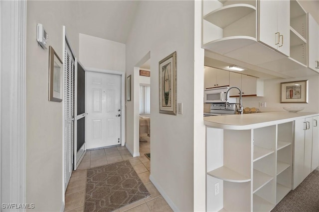 corridor with light tile patterned floors and baseboards