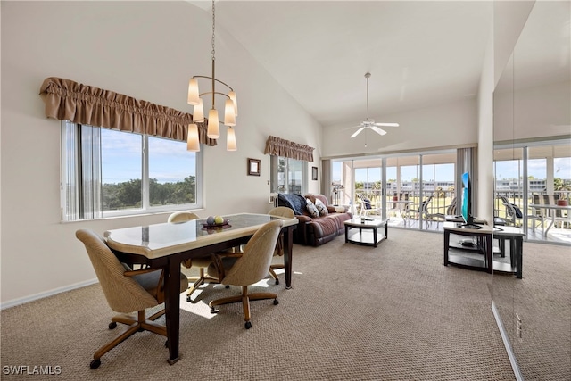 dining space with carpet, a healthy amount of sunlight, and high vaulted ceiling