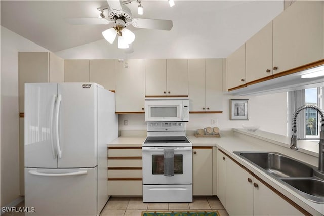 kitchen featuring white appliances, light countertops, a sink, and cream cabinetry