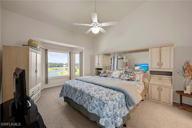 carpeted bedroom featuring high vaulted ceiling and ceiling fan