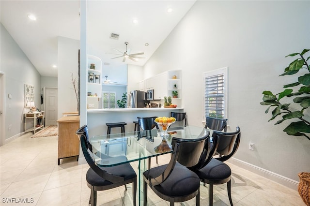 tiled dining space featuring high vaulted ceiling and ceiling fan