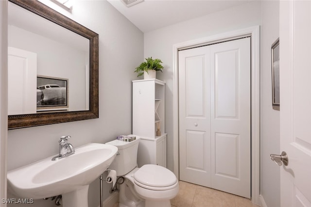 bathroom with toilet, tile patterned floors, and sink