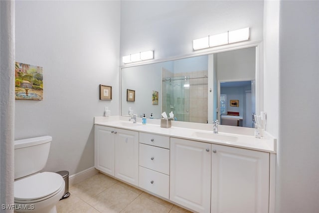 bathroom with tile patterned floors, vanity, toilet, and an enclosed shower